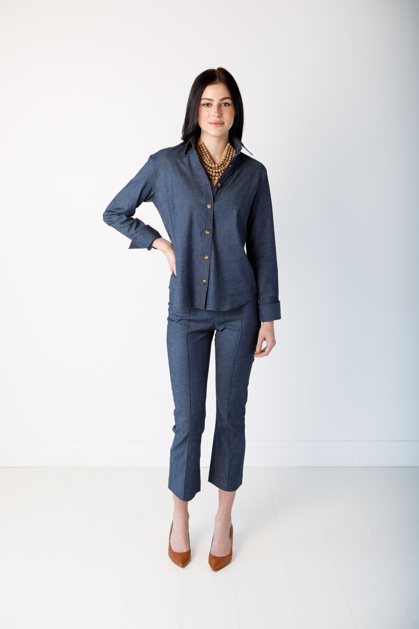 Woman wearing a blue long sleeve top against a white background