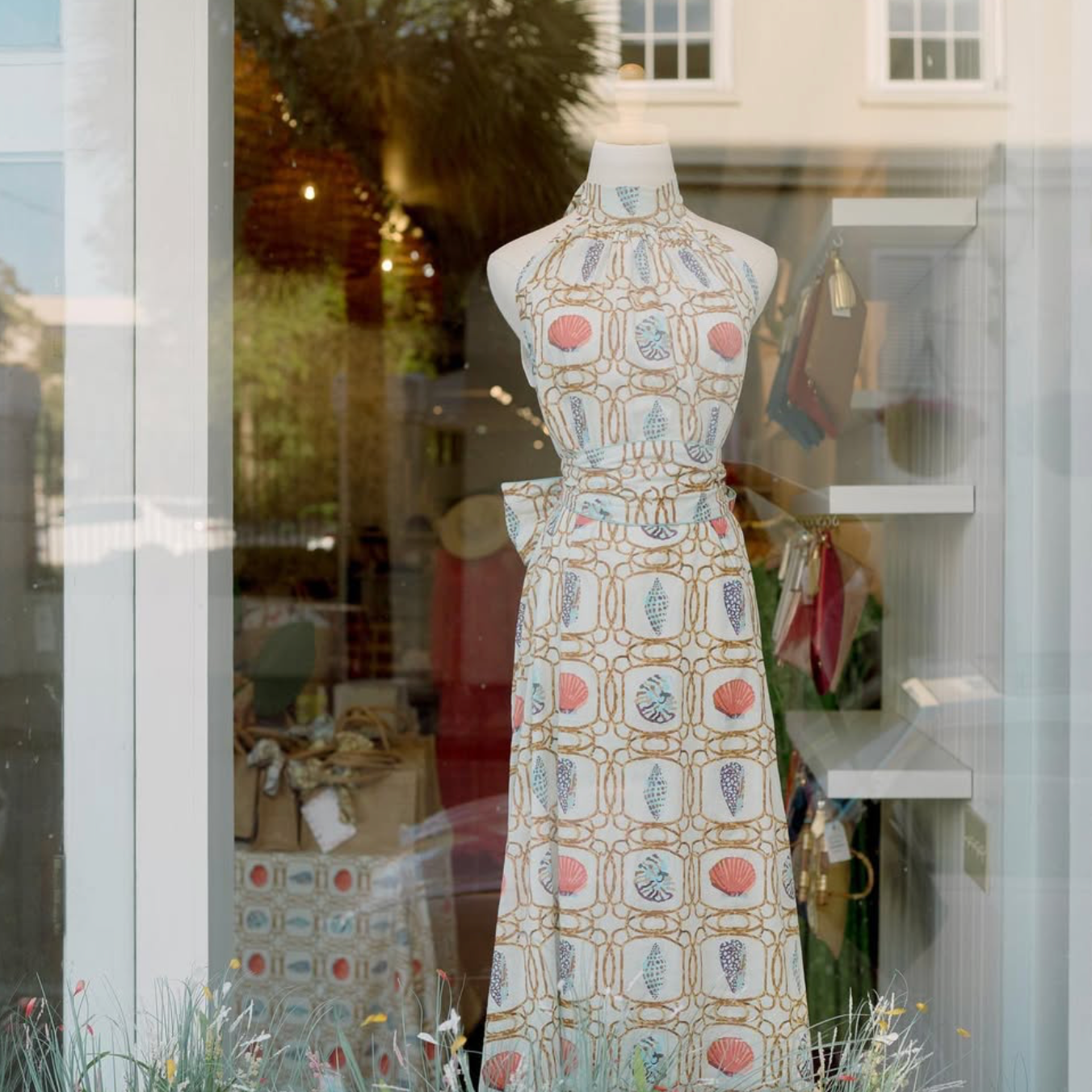 Mannequin wearing a patterned dress in front of a store window